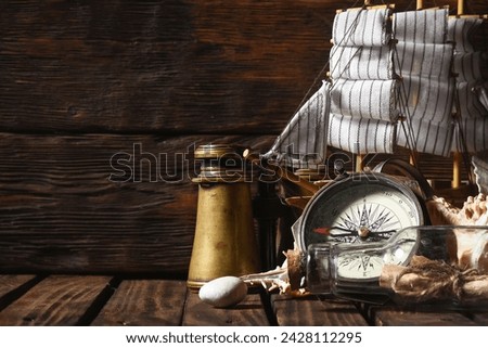 Sea travel or piracy concept background. Sea ship boat and compass on the wooden desk table background.