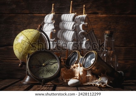 Sea travel or piracy concept background. Sea ship boat and compass on the wooden desk table background.