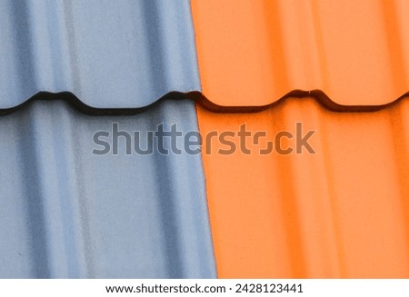 It is a photo of light brown and grey roof tiles. It is close up view of colorful tiles of a roof