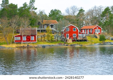 A typical Swedish red houses vith lake, Falu Rödfärg Royalty-Free Stock Photo #2428140277