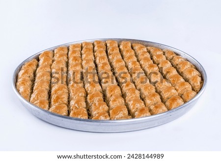 Top view of diamond cut pistachio baklava on a tray isolated on white background. Royalty-Free Stock Photo #2428144989