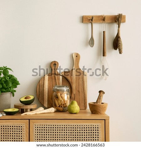 Interior design of kitchen space with rattan commode, boho chair, ladder,  cutting board, herbs, vegetables, bread, eggs, pitcher, food and kitchen accessories. Home decor.  Template. 