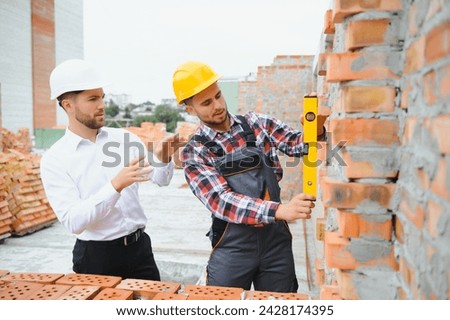 Builder and engineer on construction site.