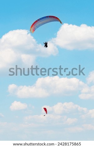 Two parachutes on cloudy sky background. Paragliding activity in Fethiye Oludeniz. Extreme sports idea concept. Vertical photo. Metaphorical meaning of freedom.