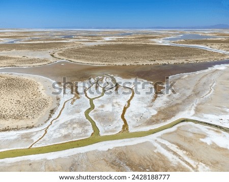 Drone view of dead salt lake Tuz in Turkey. Landscape is like on Moon or Mars, everything dried covered with salt. Here, edible salt is extracted and processed in factory or factory. Alien landscape. Royalty-Free Stock Photo #2428188777