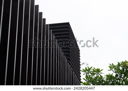 A minimalist architectural detail features a modern building with clean lines and a sleek black design. The horizontal pattern on the structure creates visual interest
