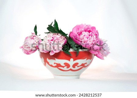 Kazakh traditional bowl —  piala with national ornament filled with blooming peonies. Pefrect photo for Nauryz greetings Royalty-Free Stock Photo #2428212537