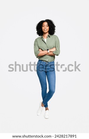 An African-American woman in a olive shirt and blue jeans, standing with confidence and a gracious smile, perfect for themes of modern professionalism and approachable leadership, full length Royalty-Free Stock Photo #2428217891