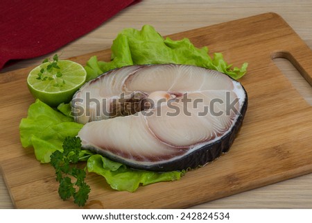 Raw blue shark steak with salad leaves and lime