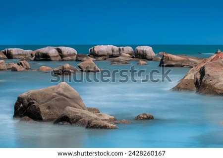 Rocky beach with blue sky . long exposure photography