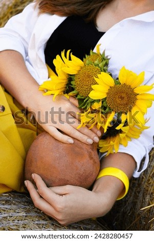 The girl is holding a jug with sunflowers in her hands. Concept Ukrainian traditions, agronomy