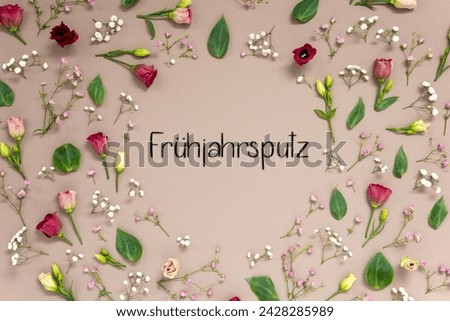 Flower Arrangement With German Text Fruehjahrsputz Means Spring Cleaning. Colorful Spring Blossoms And Flowers Like Roses Building A Frame. Flat Lay With Brown Paper Background