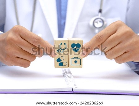 Hand holding a wooden block cube with healthcare medical icon symbol. Medical and health concept.