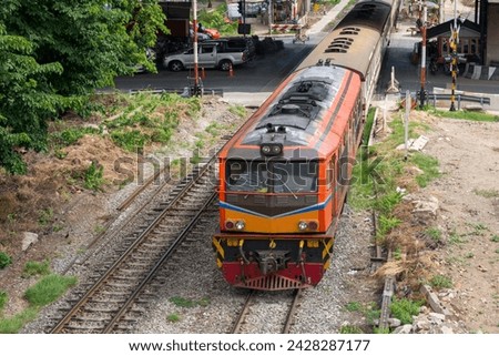 The diesel electric locomotive of the rapid train was moving out of the station through a busy intersection, above view from the bridge near the junction. Royalty-Free Stock Photo #2428287177