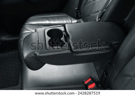 Armrest in premium car with cup holder for rear seats row. Car Leather Seats and rear passengers Armrest. Royalty-Free Stock Photo #2428287519