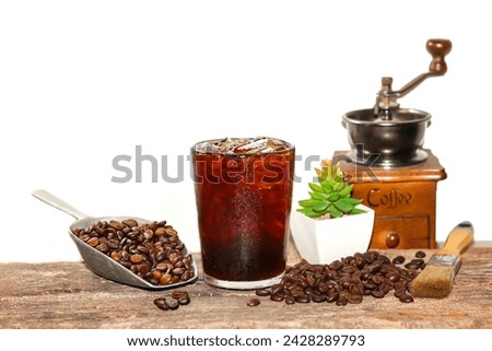 Americano ice coffee and coffee beans and coffee grinder vintage style put on old wooden with isolated picture.