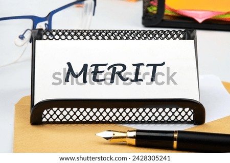 Business and merit concept. MERIT written on a business card on the table