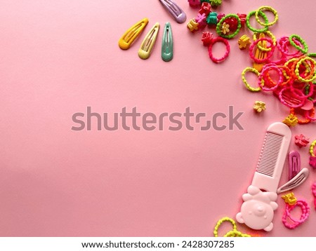 A set of accessories for a little girl on a pink background. Hairpins, comb, hair bands. Fashionable hair accessories for little girls. Flat styling. Top view 
