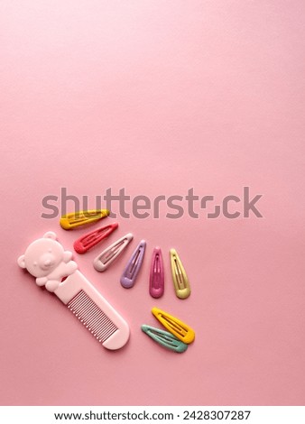 A set of accessories for a little girl on a pink background. Hairpins, comb, hair bands. Fashionable hair accessories for little girls. Flat styling. Top view 