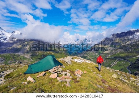 Hiker and camp site, sustenpass (susten pass), swiss alps, switzerland, europe Royalty-Free Stock Photo #2428310417