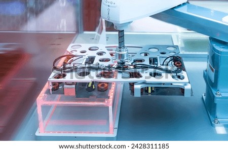 artificial intelligence machine at industrial manufacture factory for toroidal coils with magnetic ferrite core wrapped in copper wire on electronic components pile Royalty-Free Stock Photo #2428311185
