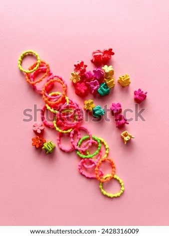 A set of accessories for a little girl on a pink background. Hairpins, comb, hair bands. Fashionable hair accessories for little girls. Flat styling. Top view