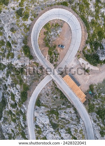 Top-down aerial view of the Nus de Sa Corbata hairpin turn in the Serra Tramuntan of Mallorca near Coll de Reis mountain pass Royalty-Free Stock Photo #2428322041