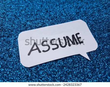 Assume writting on blue background. Royalty-Free Stock Photo #2428323367