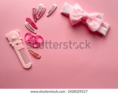 A set of accessories for a little girl on a pink background. Hairpins, comb, hair bands. Fashionable hair accessories for little girls. Flat styling. Top view