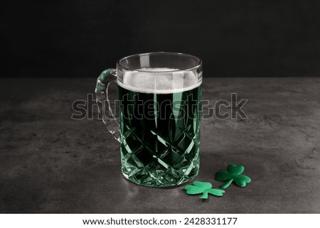 St. Patrick's day celebration. Green beer with decorative clover leaves on grey table