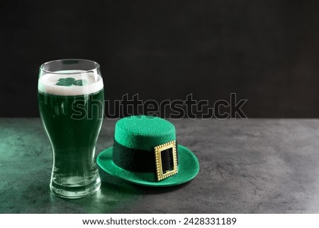 St. Patrick's day celebration. Green beer with decorative clover leaf and leprechaun hat on grey table. Space for text
