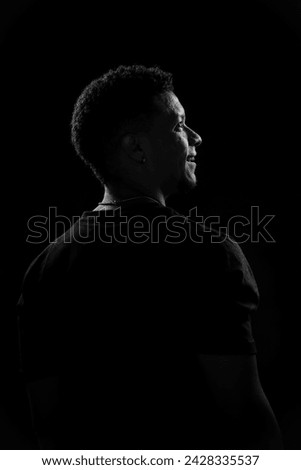 Low key of young Brazilian man in profile. black and white photography Royalty-Free Stock Photo #2428335537