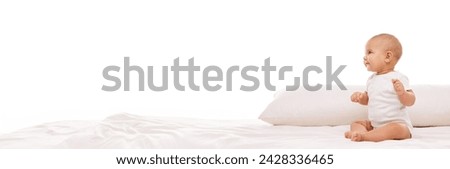 Portrait of beautiful little baby, adorable girl, toddler in white clothes posing on bed against white background. Concept of childhood, family, care, infancy. Banner. Empty space to insert text, ad Royalty-Free Stock Photo #2428336465
