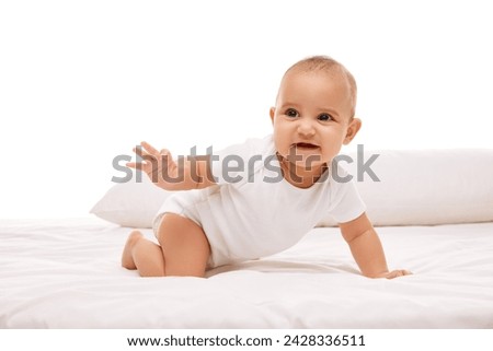 Beautiful little girl, child n white clothes lying, playing on bed, looking against white background. Stages of baby growth. Concept of childhood, family, care, motherhood, infancy, heath Royalty-Free Stock Photo #2428336511