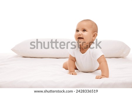 Smiling, positive, adorable little girl, baby, toddler lying on bed, looking upwards against white background. Concept of childhood and family, care, motherhood, infancy and heath Royalty-Free Stock Photo #2428336519