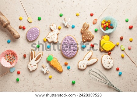 Glazed color gingerbread Easter figures - rabbit, chicken, egg, carrot   on bright background. Happy Easter. Top View Royalty-Free Stock Photo #2428339523