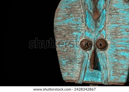 Close up of a wooden Kota reliquary figure from Gabon, isolated on a black background. Tribal African art, showcasing masterful craftsmanship and spiritual symbolism. Royalty-Free Stock Photo #2428342867