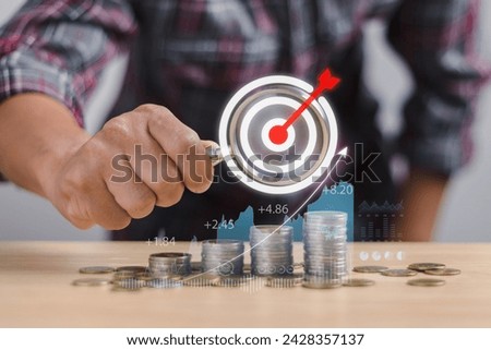 investor or trader holding magnifying glass with target icon pointing at coin overlaid with graph Show growth of financial profit and dividends from investment, funds, stock market, interest.