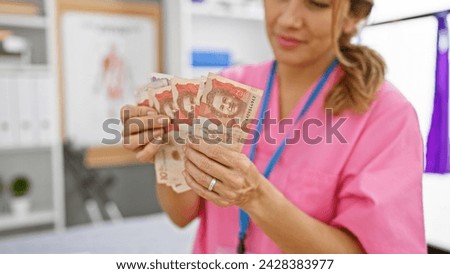 Hispanic woman in scrubs examining colombian pesos in a clinic