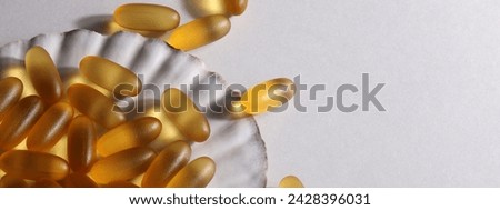 everyday supplements, wellness, multivitamin, healthy lifestyle concept. Vitamins Omega 3 on shell on white background. copy space. banner Royalty-Free Stock Photo #2428396031