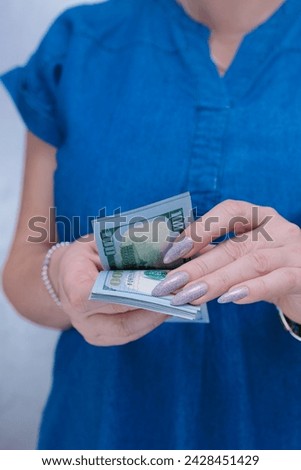 woman's hands holding American dollar paper bills