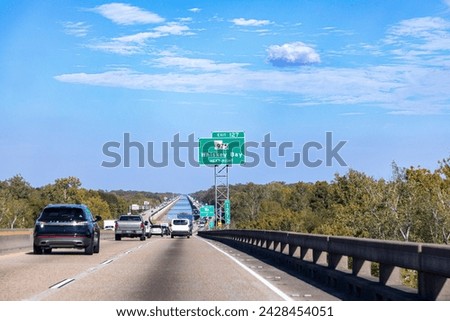 driving along the coastal  highway in Louisiana and passing the junction whiskey bay with blue sky Royalty-Free Stock Photo #2428454051