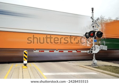 Blurred freight train in motion at crossing gate