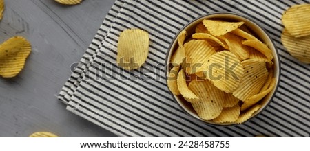 Organic Crinkle Sour Cream and Onion Potato Chips in a Bowl, top view. Flat lay, overhead, from above. Royalty-Free Stock Photo #2428458755