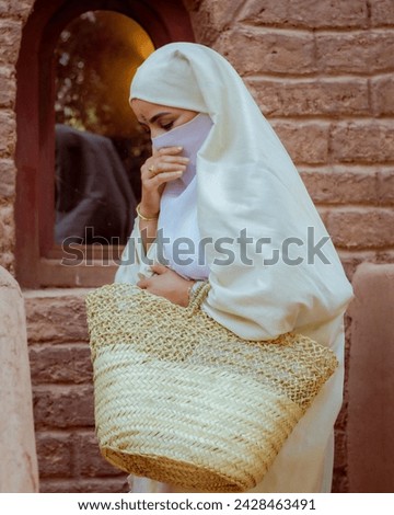 The Haik or also called “izar”, is one of the emblematic and traditional Moroccan outfits that women, but also men, wore outside and over their clothes. In a Muslim land, believers attach extreme impo Royalty-Free Stock Photo #2428463491