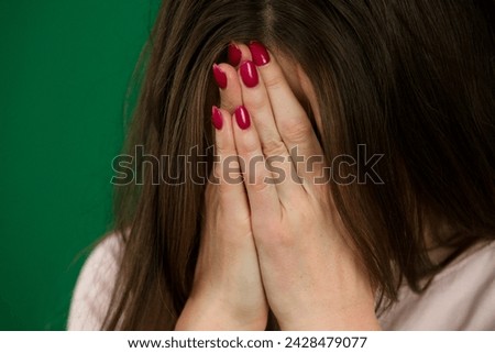 Beautiful European young businesswoman sit against body parts of a young woman on a green background chromakey. High quality photo
