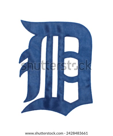 A navy blue letter D in Collins Old English Regular font.  Fabric stitched Detroit tigers American professional major league baseball brand logo photo from their jersey.  isolated on white background Royalty-Free Stock Photo #2428483661