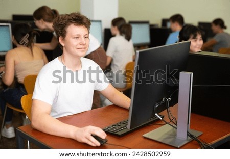 Modern boy student learning basics of programming in group course in computer college Royalty-Free Stock Photo #2428502959