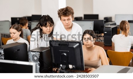 Teenagers using computer during computer science lesson in classroom. Boy and girls solving task together. Royalty-Free Stock Photo #2428503507