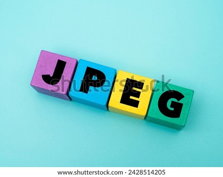 A coloured wooden block with word “JPEG” on it. JPEG stands for “Joint Photographic Experts Group”